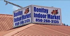 Photo Showing the blue and white color business sign "Bonifay Indoor Market 850-260-3135" that is displayed along the top of the red colored roof.