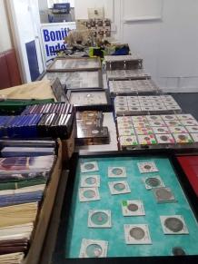 Photo of vendor table displaying miscellaneous coins and currency for sale.